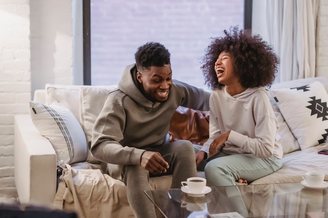 Couple sitting on the couch laughing