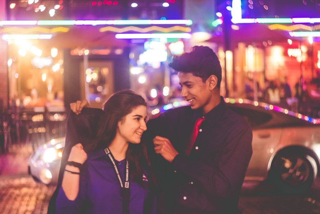 Man helping woman into a coat