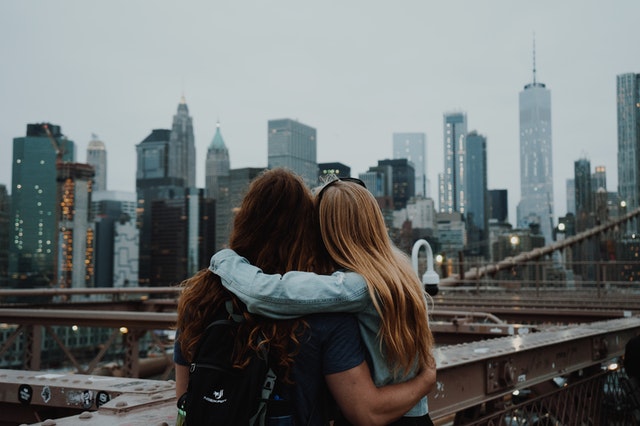 Couple arm in arm looking over a cityscape