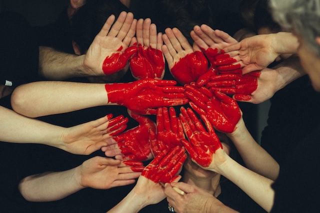 Group of hands with a painted heart on them