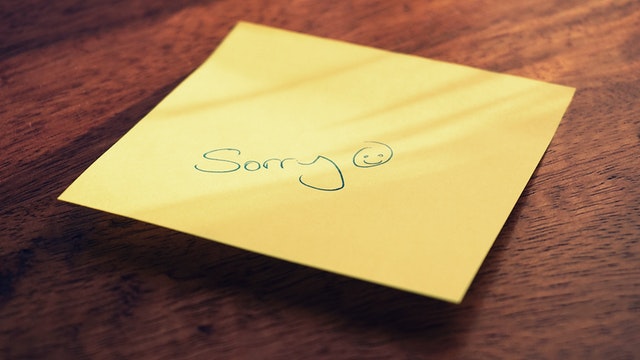 Post-it note saying "Sorry" with a smily face