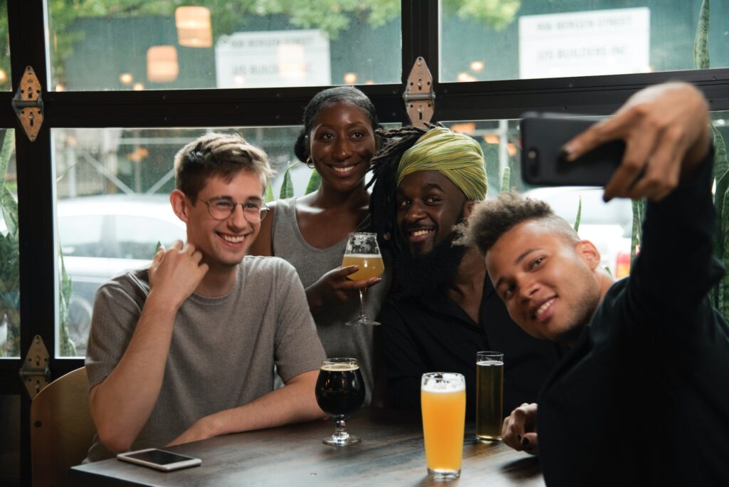 Happy multiethnic friends taking selfie on smartphone in cafe
