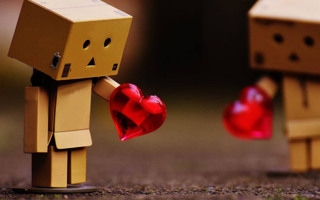 little robot box looking sad holding a heart